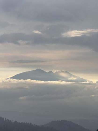Mountain ridge above a sea of cloud at sunrise